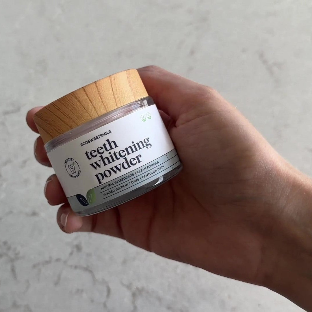 Hand holding Eco Bright Smile teeth whitener jar